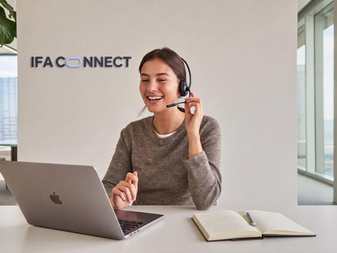A member of the IFA Connect team on a headset, smiling during a call